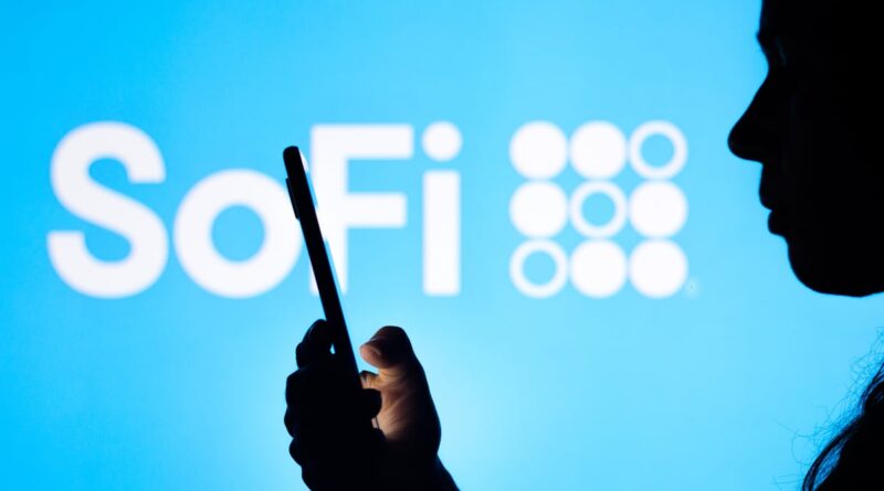 Person using smartphone with SoFi logo in the background.